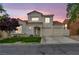 Charming two-story home features a terracotta roof, stucco facade, and a well-manicured front yard at dusk at 2124 Rising Mist St, Las Vegas, NV 89134