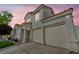 Two-story stucco home with terracotta roof showcases a two-car garage, and manicured lawn at dusk at 2124 Rising Mist St, Las Vegas, NV 89134