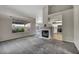 Spacious living room with a fireplace, large window, and an open view to the modern kitchen at 2124 Rising Mist St, Las Vegas, NV 89134