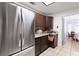 Kitchen with stainless steel appliances and dark wood cabinets with dining area view at 2231 Hallston St, Las Vegas, NV 89134