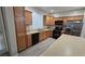 Well-lit kitchen features wood cabinets, black appliances, stainless steel refrigerator, and an island at 2737 Rimbaud St, Henderson, NV 89044