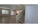 Bright living room featuring wood-look flooring, stairs, and large windows with plantation shutters at 2737 Rimbaud St, Henderson, NV 89044