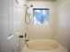 Shower over bathtub with textured tile and a window at 3217 Symphony Dr, Las Vegas, NV 89146