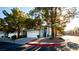 Attractive blue two-story townhome featuring a white garage door, neat landscaping, and mature trees at 3217 Symphony Dr, Las Vegas, NV 89146