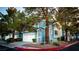Attractive blue two-story townhome featuring a white garage door, neat landscaping, and mature trees at 3217 Symphony Dr, Las Vegas, NV 89146