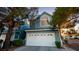 Charming two-story home with a white garage door and light blue exterior with mature landscaping at 3217 Symphony Dr, Las Vegas, NV 89146