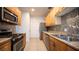 A kitchen with wood cabinets, stone countertops, stainless steel appliances and backsplash at 3217 Symphony Dr, Las Vegas, NV 89146