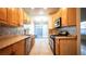 Kitchen featuring wood cabinets, mosaic backsplash, stainless steel appliances and tile flooring at 3217 Symphony Dr, Las Vegas, NV 89146