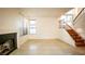 Open-concept living room features neutral tile flooring, fireplace, staircase, and large windows at 3217 Symphony Dr, Las Vegas, NV 89146