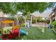 Turf backyard with a playground, playhouse, and patio space at 3218 Mura Del Prato Ave, Henderson, NV 89044