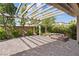 Paver patio featuring a pergola cover, stone bench seating, and lush landscaping at 3218 Mura Del Prato Ave, Henderson, NV 89044