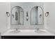 Elegant bathroom vanity featuring dual sinks, decorative mirrors, stylish wallpaper, and modern fixtures at 3218 Mura Del Prato Ave, Henderson, NV 89044
