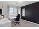 Modern bedroom with a black accent wall, a window with blinds, desk, chair and minimalist decor, exuding contemporary style at 3218 Mura Del Prato Ave, Henderson, NV 89044