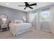 Spacious bedroom with a ceiling fan, carpet flooring, natural light, and a calming ambiance for relaxation at 3218 Mura Del Prato Ave, Henderson, NV 89044