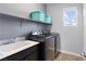 Functional laundry room featuring a modern washer and dryer set, ample storage, and a sink for added convenience at 3218 Mura Del Prato Ave, Henderson, NV 89044