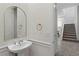 Stylish powder room features an elegant vanity, arched mirror, and stairs in background at 3218 Mura Del Prato Ave, Henderson, NV 89044