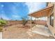 Spacious backyard featuring rock landscaping, mature tree, and a covered patio at 3448 Quiet Pueblo St, North Las Vegas, NV 89032