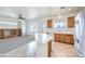 Open kitchen featuring tile floors, wooden cabinets, and stainless steel refrigerator at 3448 Quiet Pueblo St, North Las Vegas, NV 89032