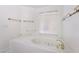 Close up of a bright white soaking tub featuring tile surround and gold fixtures at 3594 Wild Cherry Ct, Las Vegas, NV 89121