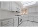 Bright kitchen with white cabinets, tile countertops, stainless steel appliances, and skylight at 3594 Wild Cherry Ct, Las Vegas, NV 89121