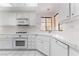 Bright kitchen features white cabinetry, tile countertops and flooring, and stainless steel appliances at 3594 Wild Cherry Ct, Las Vegas, NV 89121