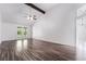 Spacious living room with high vaulted ceiling, wooden beam, ceiling fan, and dark hardwood floors at 3594 Wild Cherry Ct, Las Vegas, NV 89121