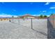 Chain link fence surrounds gravel backyard with utility structures and desert views at 3780 Shawnee Ave, Pahrump, NV 89048