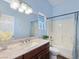 Bathroom with a full tub and shower combo, blue walls, a modern vanity and a large mirror at 3780 Shawnee Ave, Pahrump, NV 89048
