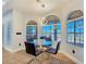Bright dining area featuring scenic views through large arched windows, complemented by a glass table at 3780 Shawnee Ave, Pahrump, NV 89048
