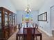 Dining room featuring a long dining table, china cabinet, arched windows and elegant lighting at 3780 Shawnee Ave, Pahrump, NV 89048