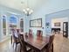 Elegant dining room flowing to piano room and featuring an arched window and a large dining table at 3780 Shawnee Ave, Pahrump, NV 89048