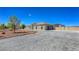 Wide driveway leading to a stucco home with an attached garage and additional metal building at 3780 Shawnee Ave, Pahrump, NV 89048