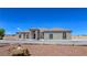 Stucco home featuring symmetrical design, arched windows, and a well-manicured desert landscape at 3780 Shawnee Ave, Pahrump, NV 89048