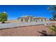 Single-story tan stucco home featuring arched windows, desert landscaping, and a circular driveway at 3780 Shawnee Ave, Pahrump, NV 89048