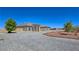 Tan stucco home with symmetrical facade, large arched windows, and a circular driveway at 3780 Shawnee Ave, Pahrump, NV 89048