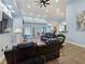 Bright living room with comfortable black leather seating, a ceiling fan, recessed lighting, and access to the patio at 3780 Shawnee Ave, Pahrump, NV 89048