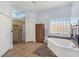Bright primary bathroom featuring a large garden tub, separate shower, and a fireplace at 3780 Shawnee Ave, Pahrump, NV 89048