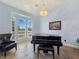 Elegant piano room featuring a grand piano, chandelier, and large bay windows for natural light at 3780 Shawnee Ave, Pahrump, NV 89048