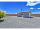 Exterior view of a small storage shed in the gravel backyard with a simple door at 3780 Shawnee Ave, Pahrump, NV 89048