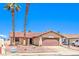 Charming single-story home with a tile roof, complemented by mature palm trees at 403 Woodridge Dr, Henderson, NV 89015