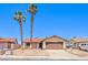 Charming single-story home featuring a two-car garage, desert landscaping, and palm trees at 403 Woodridge Dr, Henderson, NV 89015