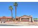 Inviting single-story home with a tile roof and desert landscaping, framed by palm trees at 403 Woodridge Dr, Henderson, NV 89015