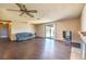 Spacious living room with hardwood floors, a ceiling fan, and a brick fireplace at 403 Woodridge Dr, Henderson, NV 89015