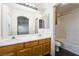 Bathroom features double sinks, warm cabinetry, large mirror, with a view to another room, and a bath tub and toilet at 4608 Snake Eyes St # 102, Las Vegas, NV 89122