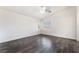 Bright, empty bedroom with dark, modern flooring, a ceiling fan, and windows, offering a blank canvas at 4608 Snake Eyes St # 102, Las Vegas, NV 89122