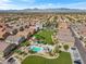 Aerial view of a residential community featuring well-maintained greenery, swimming pool, and picturesque mountain views at 4650 Ridgeley Ave # 103, North Las Vegas, NV 89084