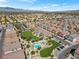 Aerial view of a residential community featuring green spaces, a pool, and neatly lined houses with mountain views at 4650 Ridgeley Ave # 103, North Las Vegas, NV 89084