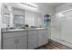 Bathroom featuring double sinks, granite counters, modern cabinetry, and shower with glass door at 4650 Ridgeley Ave # 103, North Las Vegas, NV 89084
