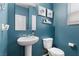 Modern bathroom features pedestal sink, toilet, and blue painted walls at 4650 Ridgeley Ave # 103, North Las Vegas, NV 89084