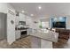 Modern kitchen featuring stainless steel appliances, white cabinetry, and granite countertops flowing to the living room at 4650 Ridgeley Ave # 103, North Las Vegas, NV 89084